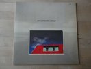 Jan Garbarek Group–Photo With Blue Sky, White Cloud, Wires, Windows And A Red..